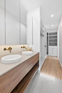 Un baño blanco con dos lavabos y una ducha. en Iluka on the Avenue- 3 bedroom, 2 bathroom. Brand new. 150m walk to shops, en Ocean Grove