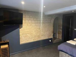 a bedroom with a bed and a tv on a wall at Loveroom En Aparté Caen in Caen +7 photos