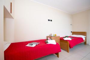 Cette chambre comprend 2 lits avec des draps rouges. dans l'établissement Sant' Andrea Vista, à Menaggio