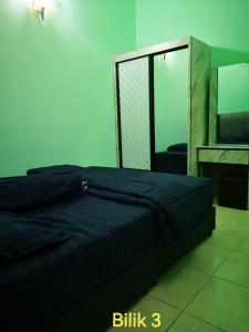 - une chambre avec un lit bleu et un miroir dans l'établissement Afwan homestay klebang melaka, à Malacca
