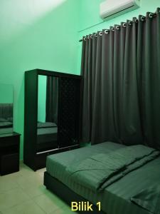 - une chambre avec un lit et un miroir dans l'établissement Afwan homestay klebang melaka, à Malacca