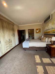 een grote slaapkamer met een groot bed en een tafel bij Elements golf reserve in Bela-Bela