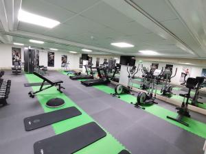 een fitnessruimte met rijen hometrainers en loopbanden bij Queens Bay Hotel in Paphos City