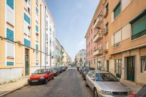 Una fila de autos estacionados en una calle de la ciudad en Serene 2BDR Apartment W/ Patio by LovelyStay, en Lisboa