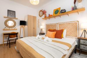 1 dormitorio con 1 cama grande con almohadas de color naranja en Serene 2BDR Apartment W/ Patio by LovelyStay, en Lisboa
