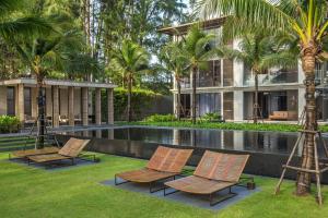 ośrodek z basenem z krzesłami i palmami w obiekcie Baan Mai Khao by Villacarte w mieście Mai Khao Beach