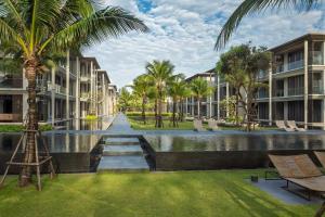 ośrodek wypoczynkowy z kanałem, palmami i budynkami w obiekcie Baan Mai Khao by Villacarte w mieście Mai Khao Beach