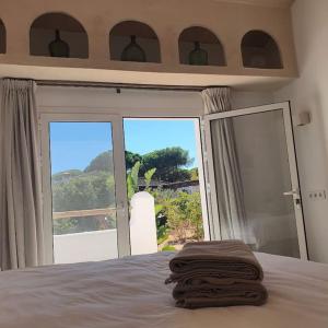 a bedroom with a bed and a sliding glass door at La Finca de Véro in Barbate
