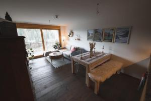 a living room with a table and a couch at Cosy, stylish new 2-bedroom flat with spa and gym in Laax