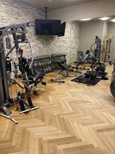 un gimnasio con varias máquinas de correr y TV en Cosy, stylish new 2-bedroom flat with spa and gym, en Laax