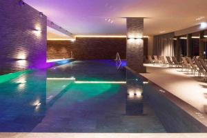 una piscina en medio de un edificio en Cosy, stylish new 2-bedroom flat with spa and gym, en Laax