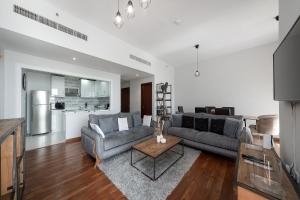 uma sala de estar com um sofá e uma mesa em Luxury 2BR at Rimal 3 em Dubai