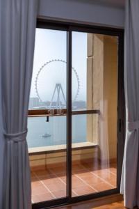 um quarto com uma grande janela com vista para a roda gigante em Luxury 2BR at Rimal 3 em Dubai