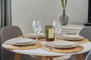 - une table avec des assiettes et des verres à vin dans l'établissement Peaceful Wrocław Apartment for 4 Guests with Balcony by Renters, à Wrocław