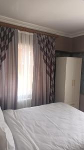 een slaapkamer met een wit bed en een raam bij Fetih Suite Home A2 in Istanbul
