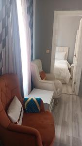 een woonkamer met een bank, stoelen en een bed bij Fetih Suite Home A2 in Istanbul