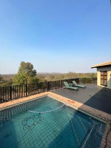 a swimming pool on a deck next to a house at Elements golf reserve in Bela-Bela
