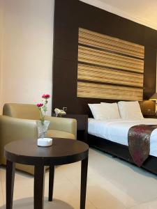 a hotel room with a bed and a coffee table at aresidencia sei putih in Medan