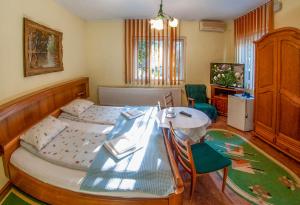 a bedroom with a bed and a table and chairs at Pensiunea Sub Cetate Deva in Deva