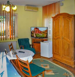 a living room with a table and a tv at Pensiunea Sub Cetate Deva in Deva