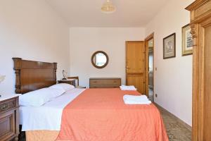 - une chambre avec un grand lit et un miroir dans l'établissement Casa Giovanni, à Cala Gonone