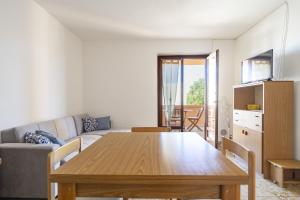 - un salon avec une table en bois et un canapé dans l'établissement Casa Giovanni, à Cala Gonone