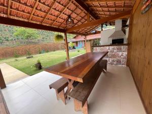 a wooden table and bench in a pavilion at Chácara cantinho na roça, Domingos Martins - Espirito Santo in Domingos Martins