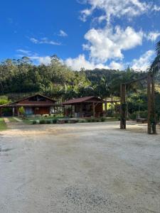 un groupe de maisons avec des montagnes en arrière-plan dans l'établissement Chácara cantinho na roça, Domingos Martins - Espirito Santo, à Domingos Martins