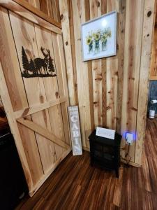 Zimmer mit einer Holzwand, einer Tür und einem Tisch in der Unterkunft Unique Country Cabin Meets Farmhouse Modern!!! in Mena