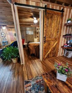 Zimmer mit einer Tür und einem Tisch mit Blumen in der Unterkunft Unique Country Cabin Meets Farmhouse Modern!!! in Mena