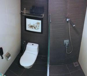 a bathroom with a toilet and a glass shower at Backpackers Cozy Apartment KL Sentral in Kuala Lumpur