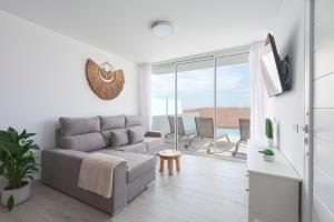 VILLA PAPAYA في تياس: غرفة معيشة مع أريكة وشرفة