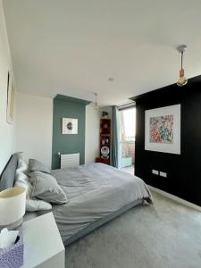 a bedroom with a large bed and a couch at Elegant Chic Living: 1 Bed In Vibrant London Area in London