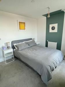 ein Schlafzimmer mit einem großen Bett und einer grünen Wand in der Unterkunft Elegant Chic Living: 1 Bed In Vibrant London Area in London