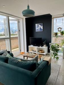 a living room with a blue couch and a table at Elegant Chic Living: 1 Bed In Vibrant London Area in London