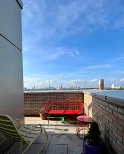 a red bench sitting on top of a brick wall at Elegant Chic Living: 1 Bed In Vibrant London Area in London