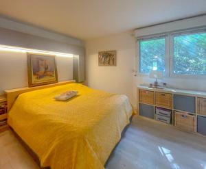 una camera da letto con un grande letto giallo e una finestra di LE BUNKER Prado Plage Velodrome a Marsiglia