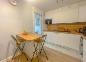 a kitchen with white cabinets and a wooden table at LE BUNKER Prado Plage Velodrome in Marseille