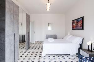 1 dormitorio con cama blanca y suelo blanco y negro en Casa Adda by Wonderful Italy, en Siracusa