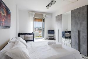 Un dormitorio blanco con una cama grande y una ventana en Casa Adda by Wonderful Italy, en Siracusa