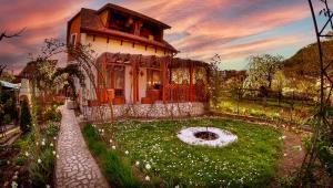 a house with a garden in front of it at Pensiunea Sub Cetate Deva in Deva