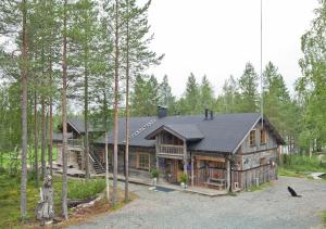 a large wooden house in the woods at Wilderness Chalet Kuusamo in Kiviperä