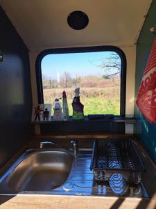 a kitchen sink with a view of a window at The Big Yellow Bus in Montchevrier
