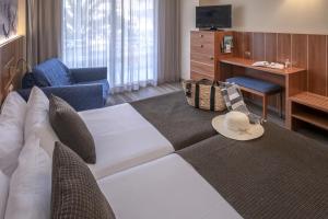 a living room with a couch and a television in a hotel room at GHT Aquarium & Spa in Lloret de Mar