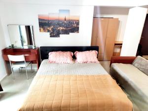 een slaapkamer met een bed met roze kussens en een bureau bij Studioul de Vis in Braşov
