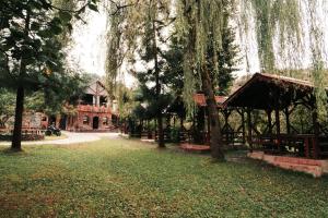 un parque con bancos y árboles y un edificio en Lome Çiftliği Otel ve Restoran en Artvin
