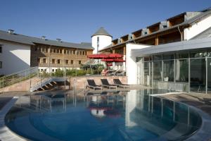 a swimming pool in front of a building at Seiser Alm Urthaler in Alpe di Siusi