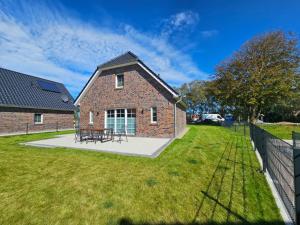 a brick house with a picnic table in the yard at Ferienhaus Golfkate A in Hage