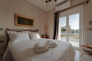 a bedroom with two towels on a bed with a window at Ponte Suites in Antirrio