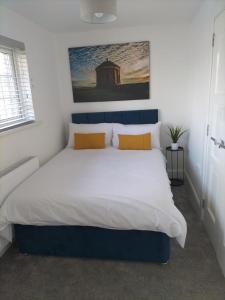 a bedroom with a large bed with yellow pillows at Binevenagh View, Magilligan Holiday Let in Limavady